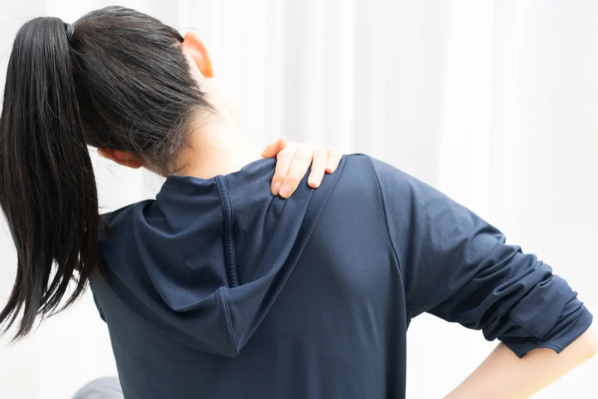 肩をおさえている女性