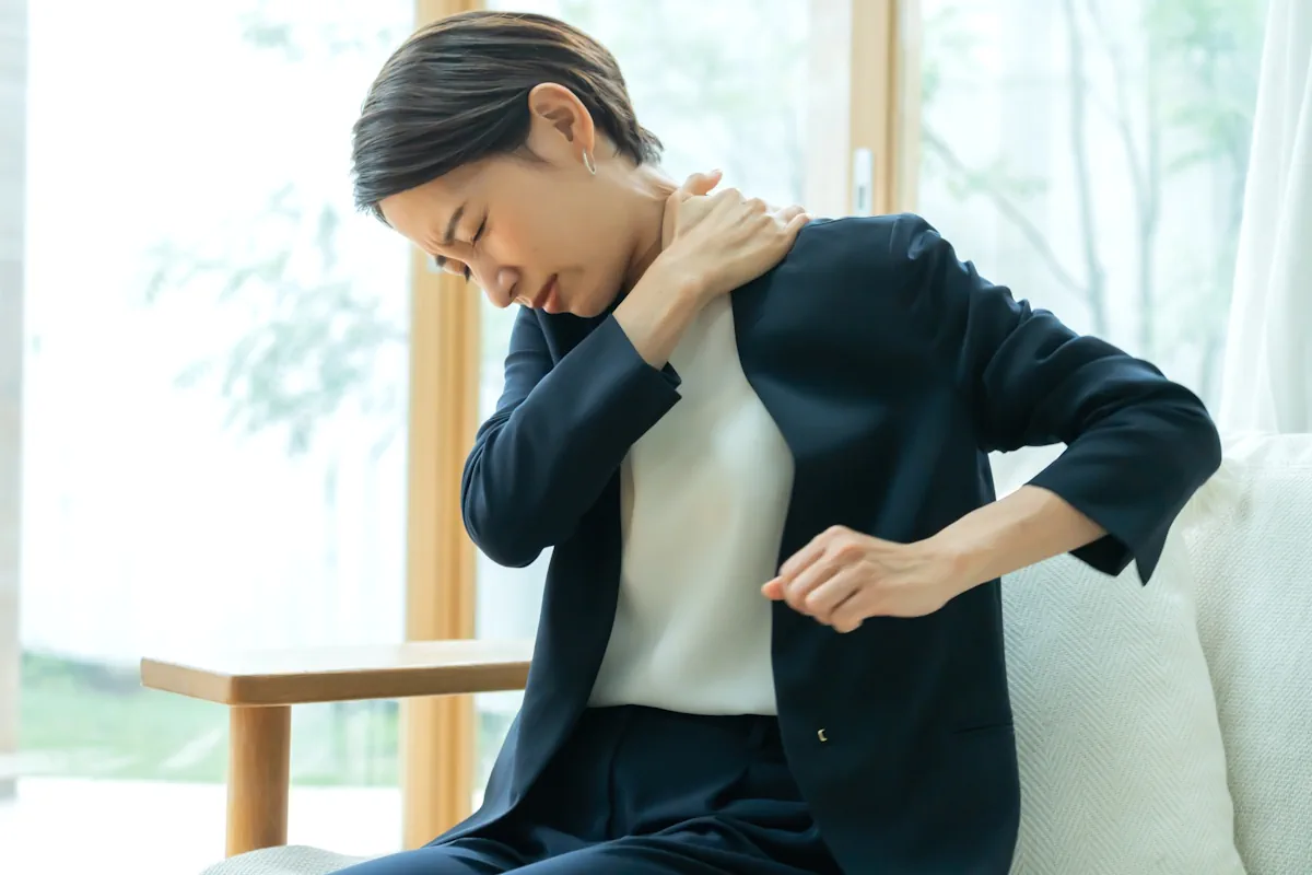 肩をおさえている女性